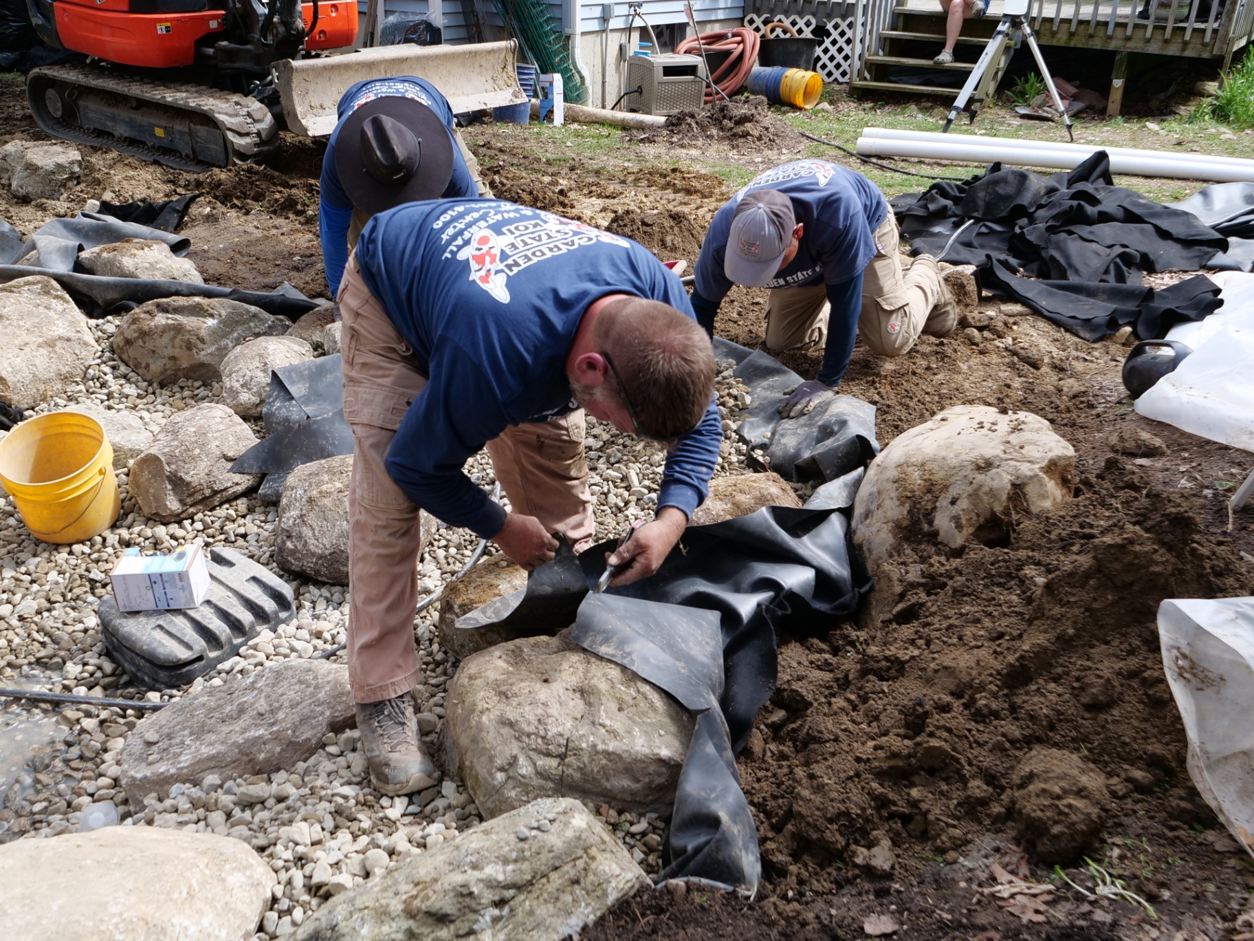 Garden State Koi crew trimming liner and setting boulders
