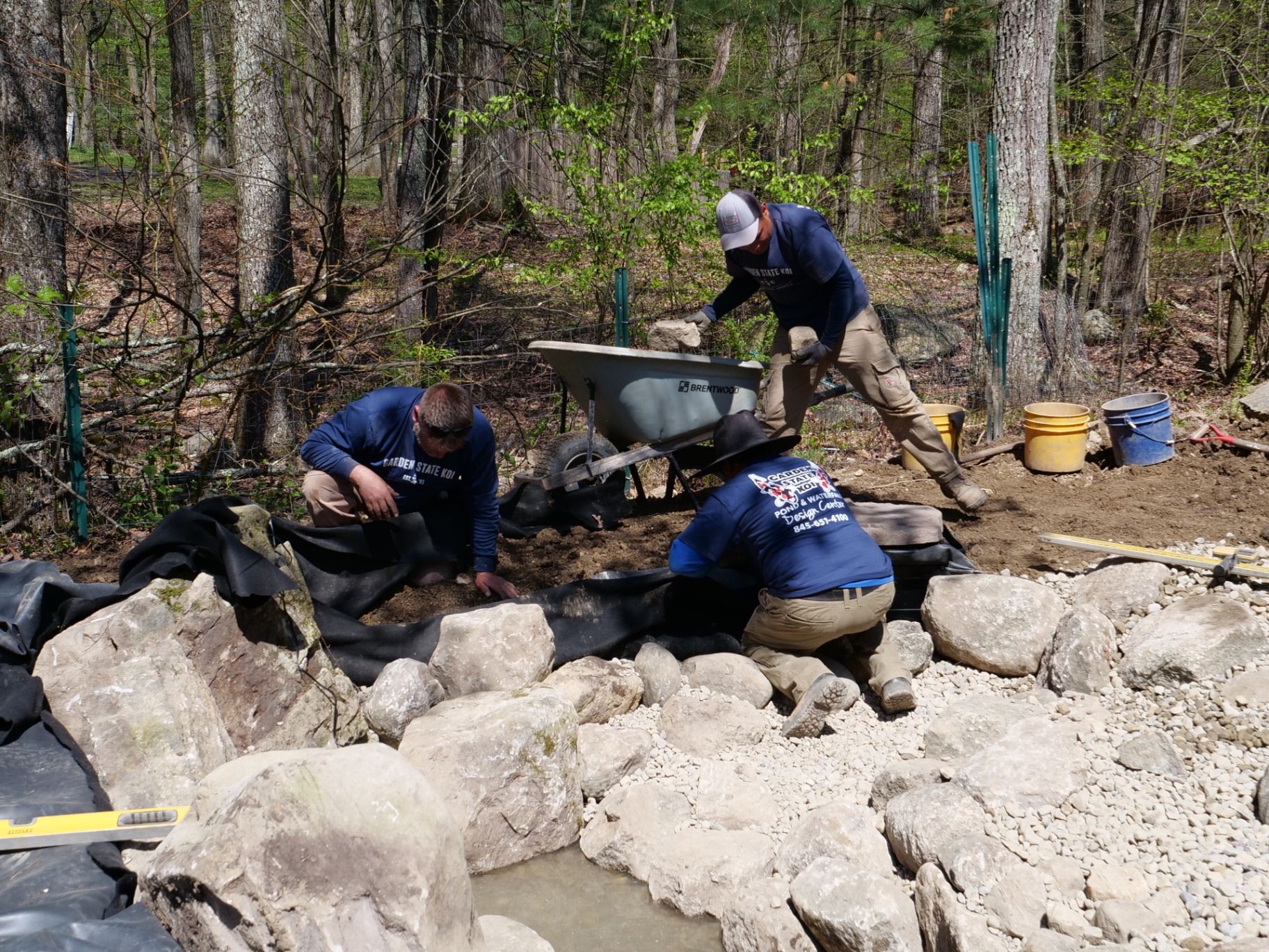 Crew finishing the wetland filter edge with stone