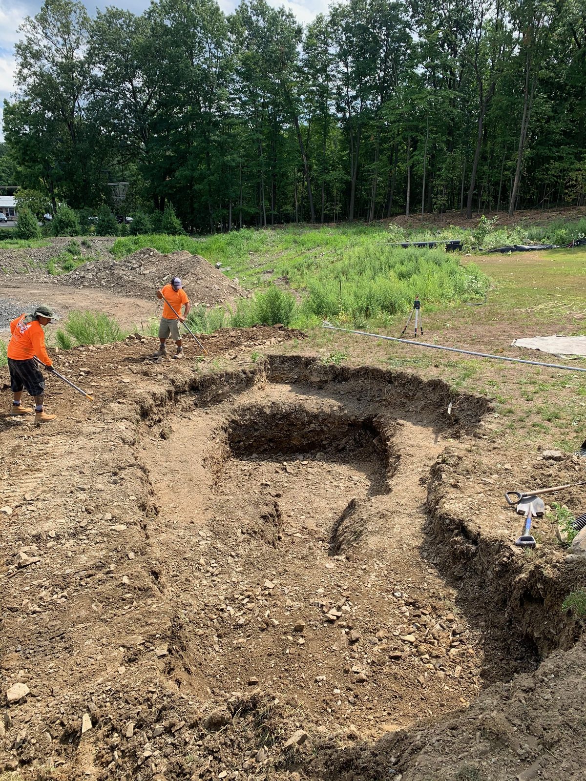 Freshly excavated pond basin marking out the shape of a planned backyard pond