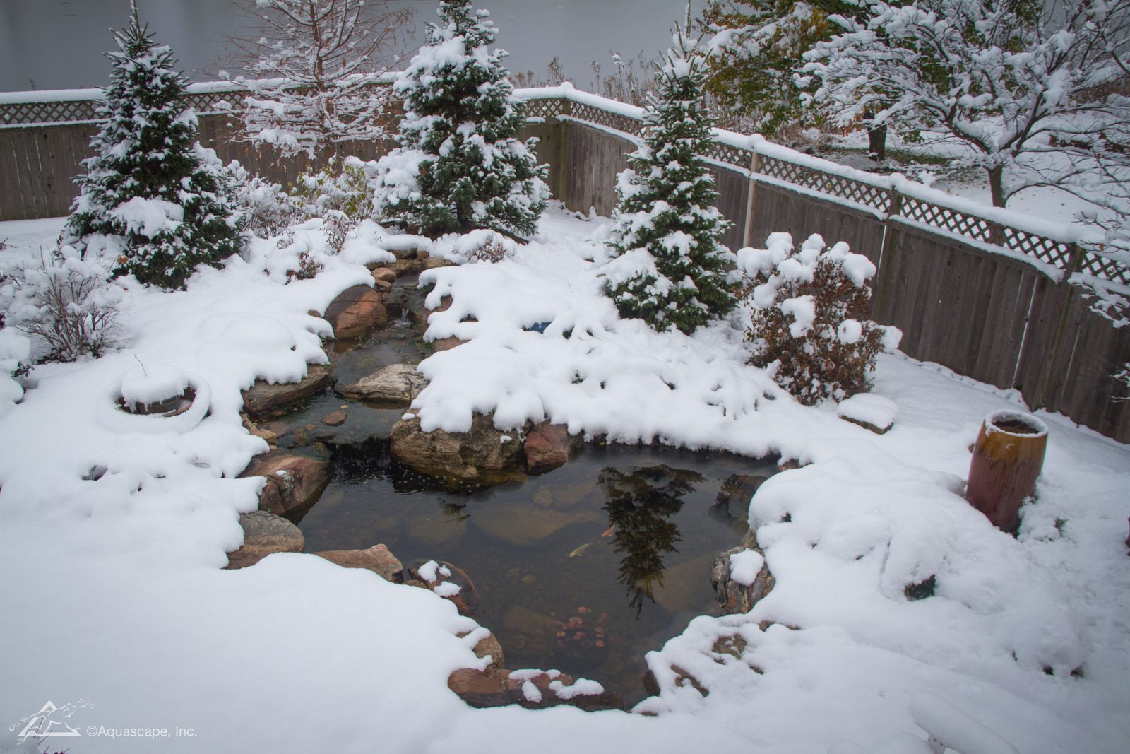Snow covered backyard pond running through a Hudson Valley winter