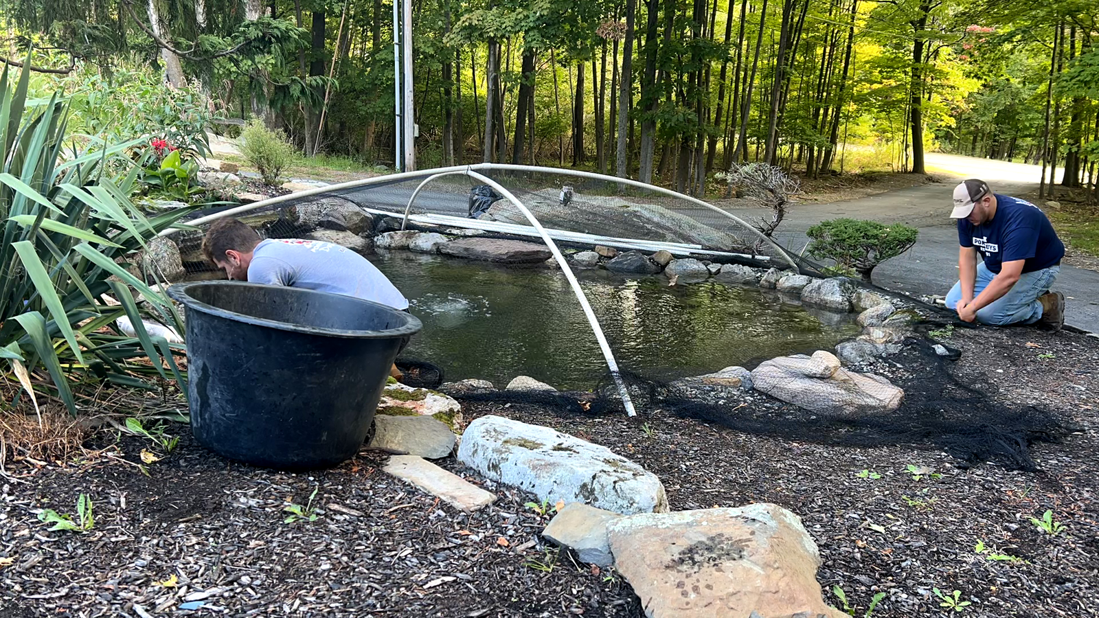 Garden State Koi technician servicing pond equipment during a maintenance visit